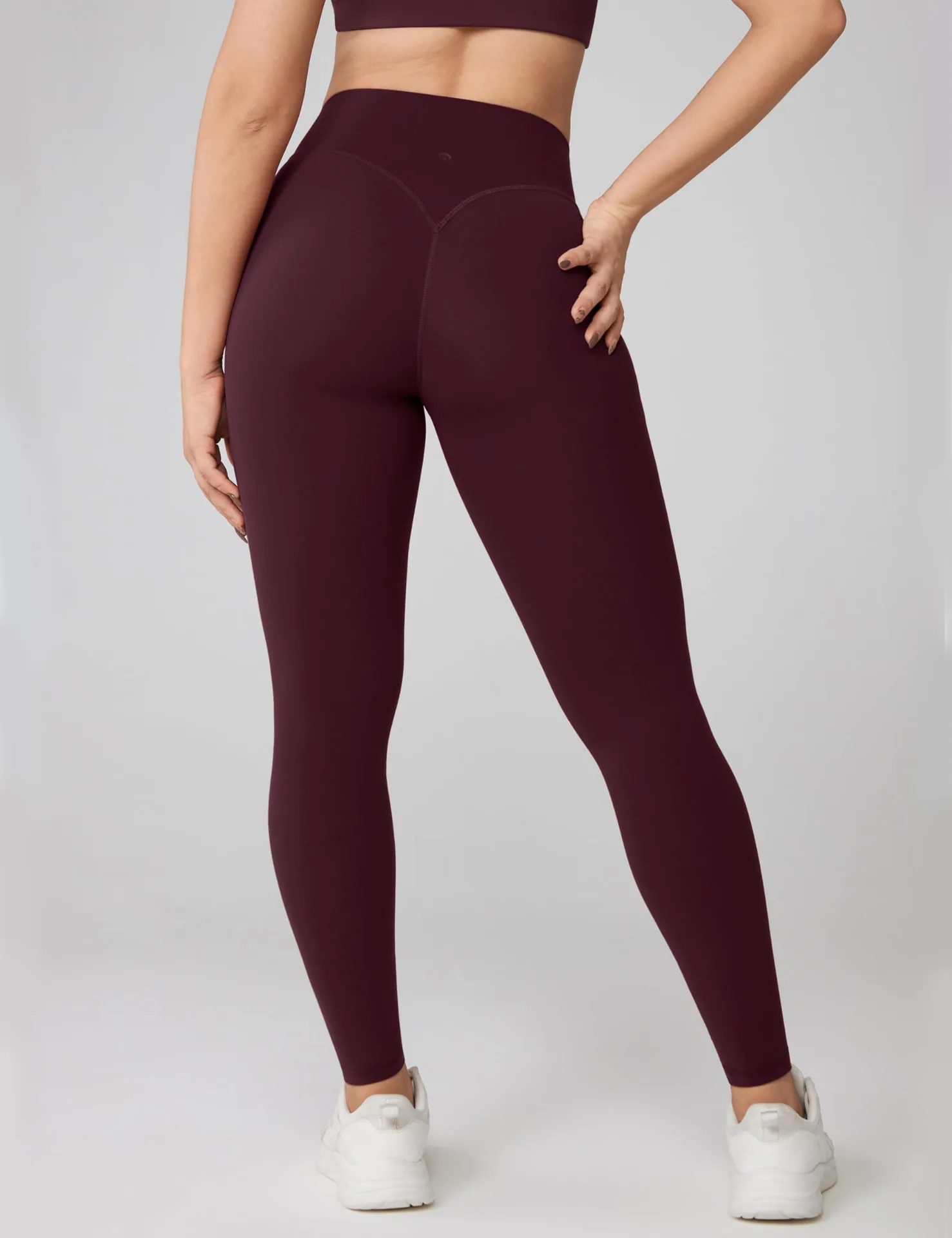 Back view of burgundy UNISSU leggings with a V-shaped back seam
