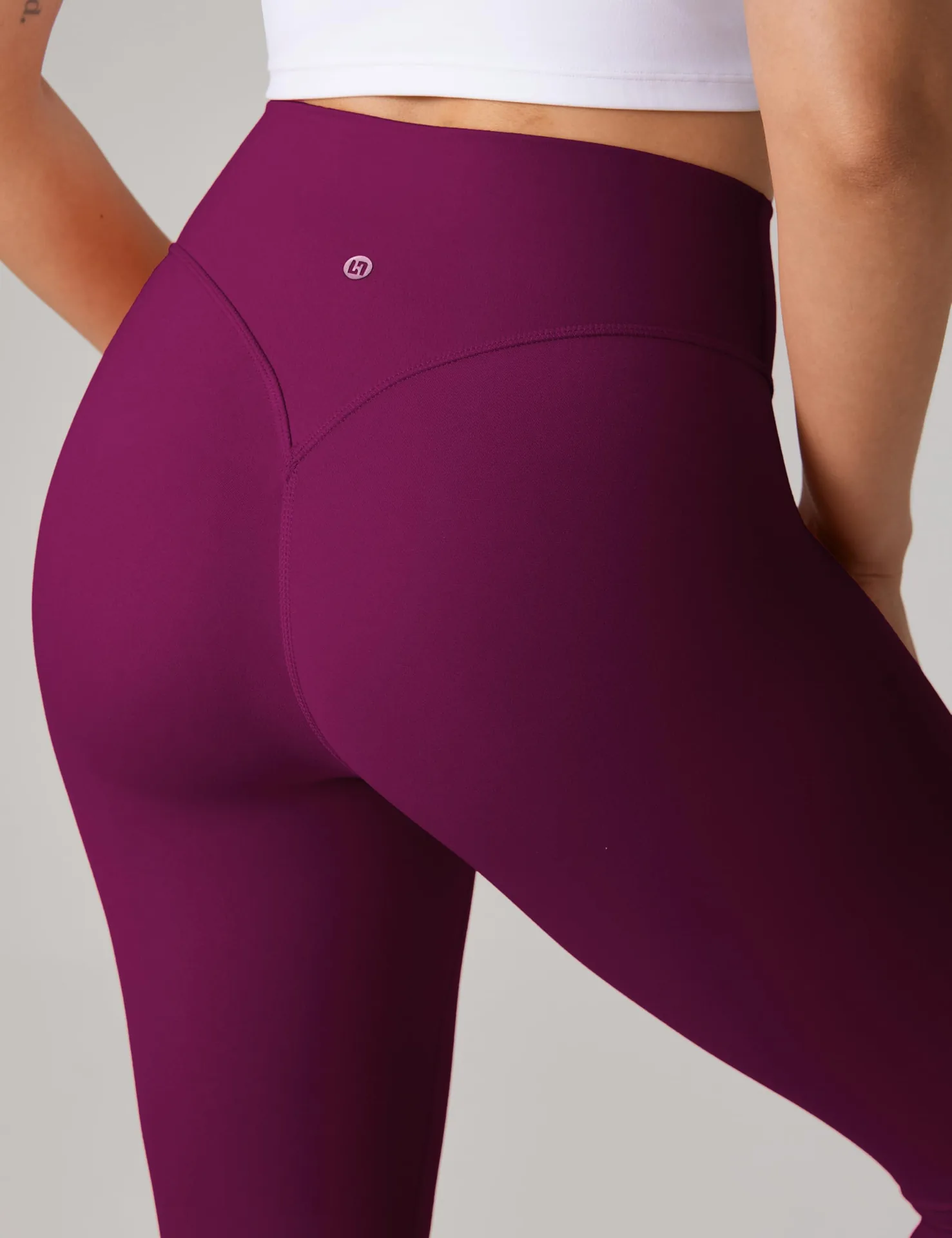 Close-up of the V-shaped back seam on magenta UNISSU leggings