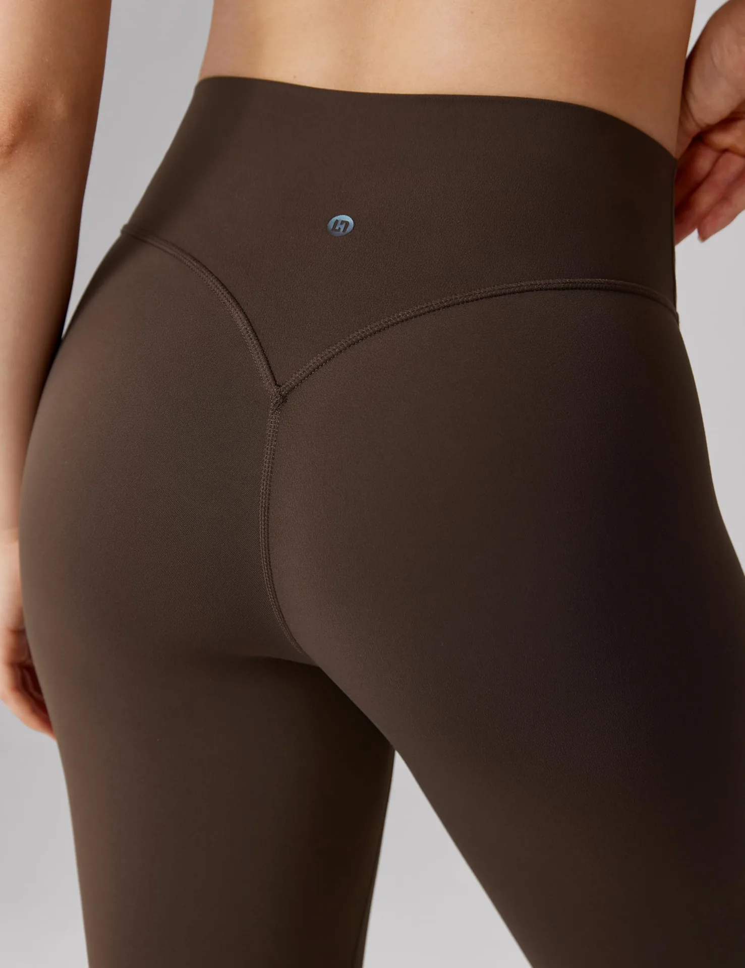 Close-up of the V-shaped back seam on brown UNISSU leggings